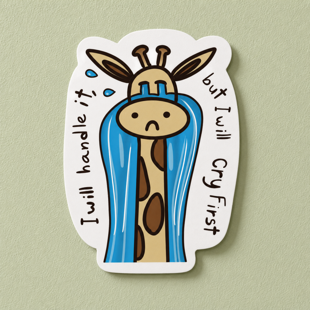 A die-cut sticker featuring a cartoon giraffe wrapped in a blue raincoat with a sad face, surrounded by the text 'I will handle it' on the left and 'but I will cry first' on the right, shown against a light sage green background.